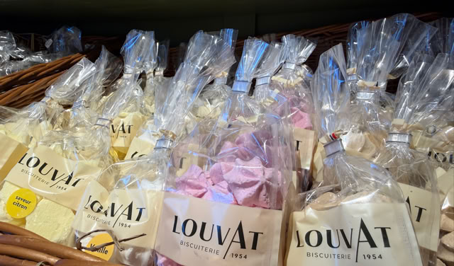 Sachets de bonbons colorés dans des paniers en osier, étiquetés "Louvat".