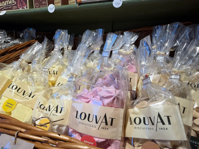 Des sachets de bonbons colorés dans des paniers en osier, avec des étiquettes "LOUVAT".