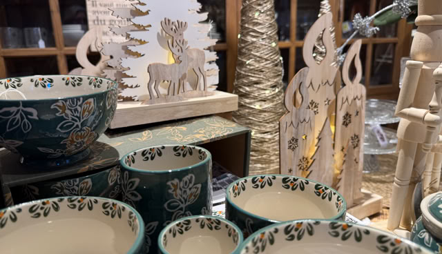 Bols décoratifs bleus et blancs avec motifs floraux, entourés de décorations en bois en forme de sapins et de rennes.