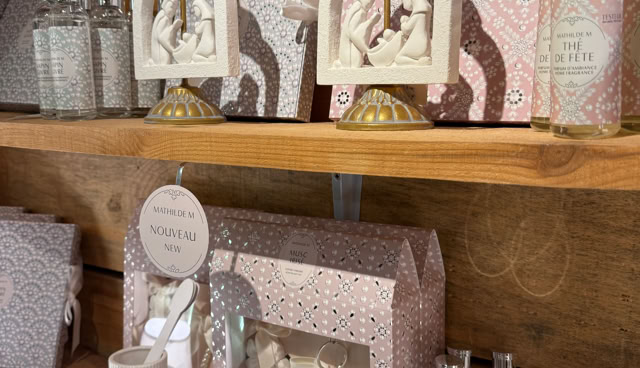 Étagères en bois avec des articles de décoration, y compris des cadres avec des figurines, des bouteilles, et des boîtes à motifs.