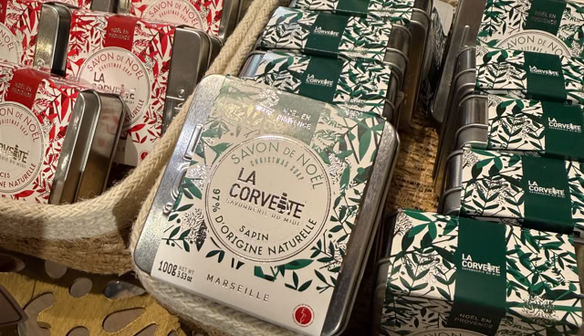 Des boîtes de thé colorées en rouge et vert avec des motifs floraux, disposées dans des paniers sur une table.